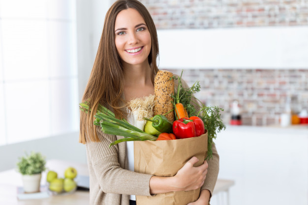beautiful-young-woman-with-vegetables-grocery-bag-home